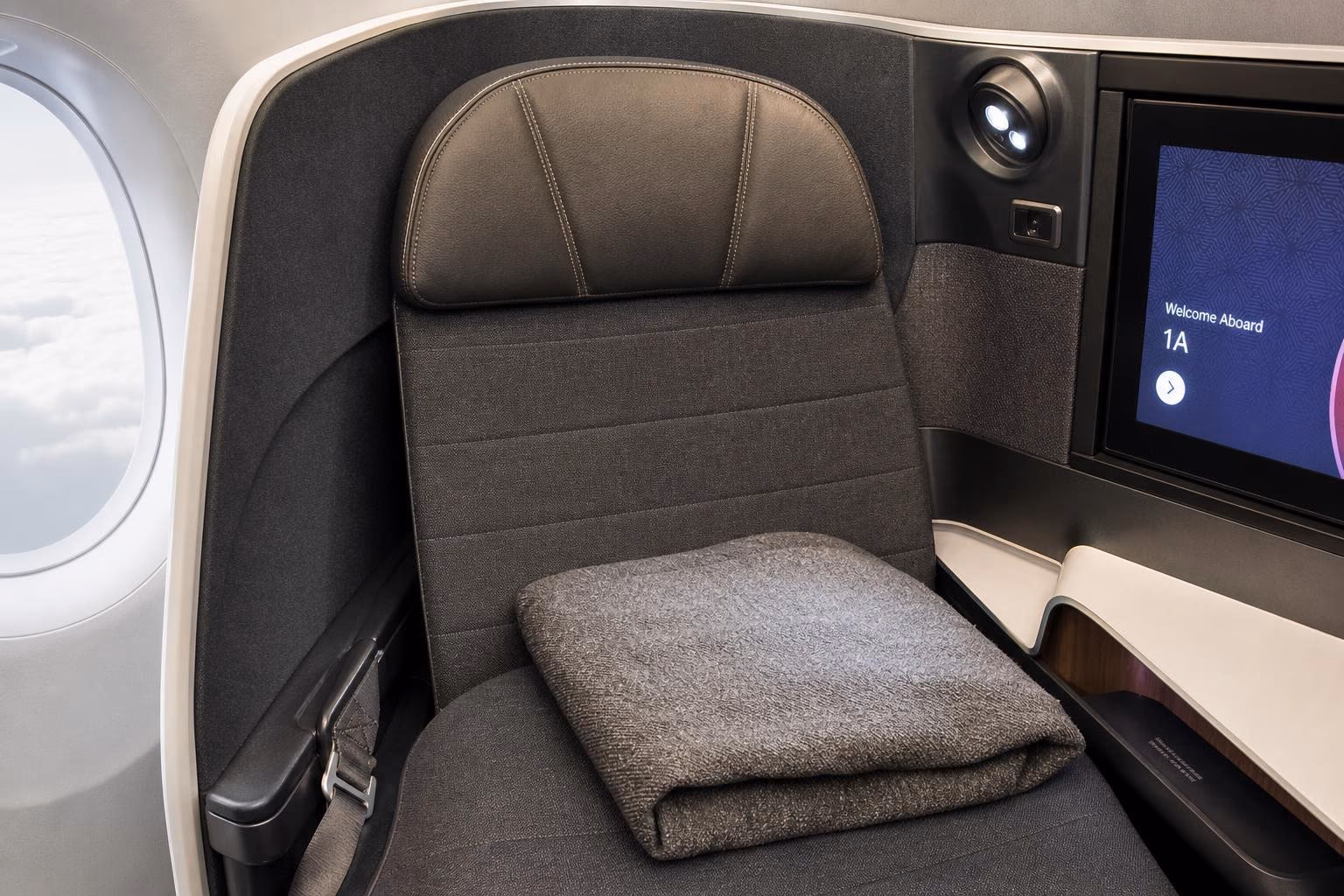 Airline business-class lie-flat seat, privacy shell, and a small window