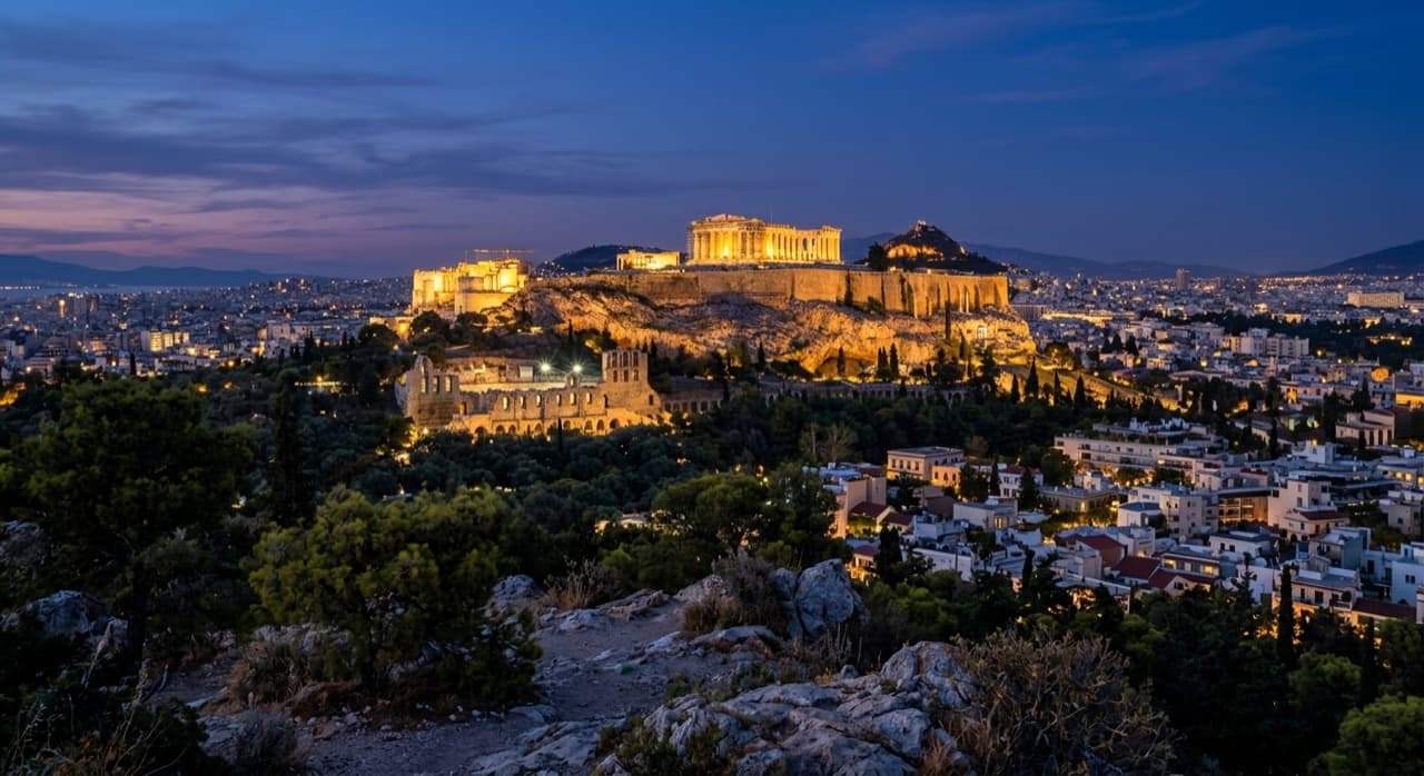 Golden-hour view over Athens with the Acropolis and the Aegean coast beyond, evoking a private jet arrival to Athens, Greece