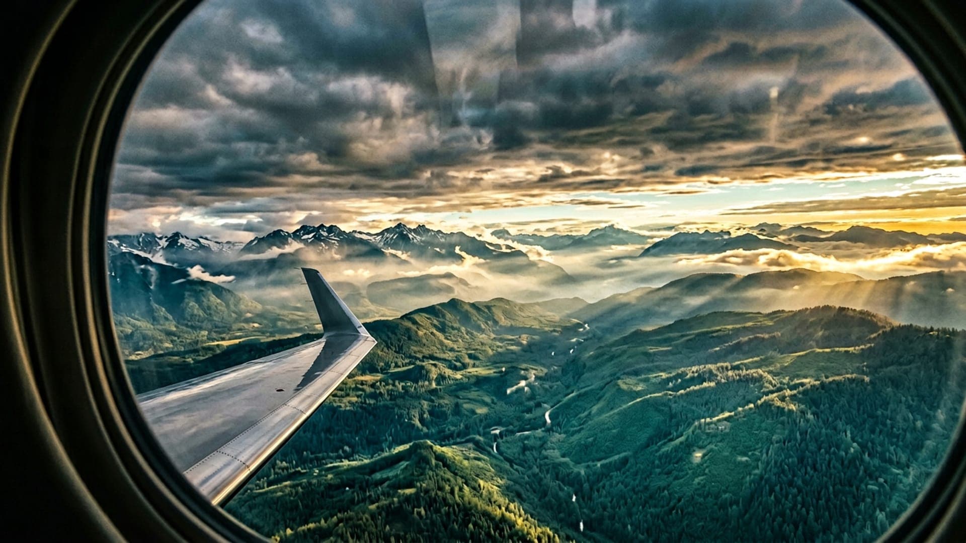 View from a private jet window over green mountains and forests